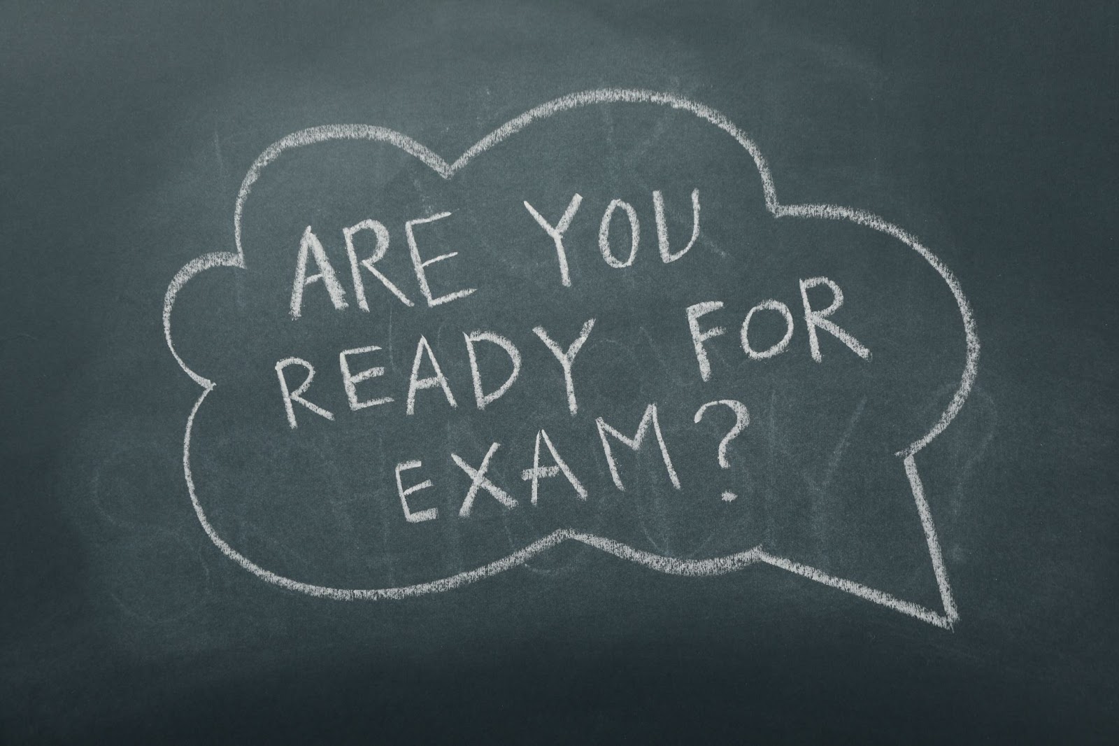 TOEFL preparation desk setup with laptop, clock, and study tools